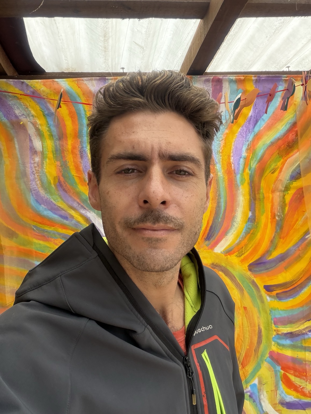 jordi amat, in front of a hand-painted flame mural in mazunte